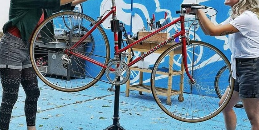 Zwei junge Frauen reparieren ein Fahrrad